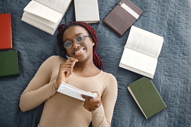 Photo jeune adolescente allongée sur son lit étudiant dans une chambre lumineuse à la maison