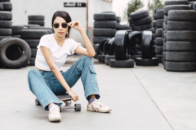 Jeune adolescente asiatique, adolescente moderne, femmes hipster de la génération z avec planche à roulettes ou planche de surf