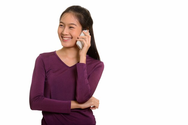 Jeune adolescente asiatique heureuse souriant et parlant sur téléphone mobile