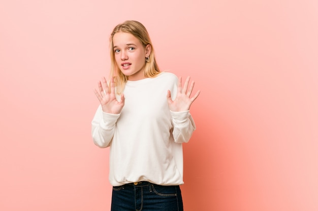 Jeune adolescente blonde femme rejetant quelqu'un montrant un geste de dégoût.