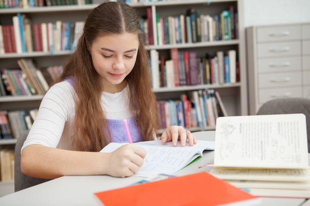 Jeune adolescente étudie à la bibliothèque