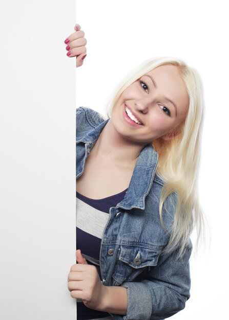 Jeune adolescente pointant sur tableau blanc fond blanc