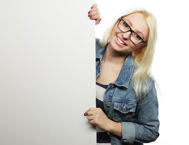 Jeune adolescente pointant sur tableau blanc fond blanc