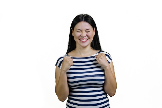 Une jeune et adorable femme asiatique heureuse se réjouit du succès isolée sur le blanc.