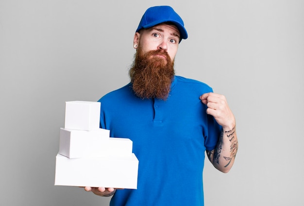 Jeune adulte cheveux roux barbu livreur cool avec des boîtes