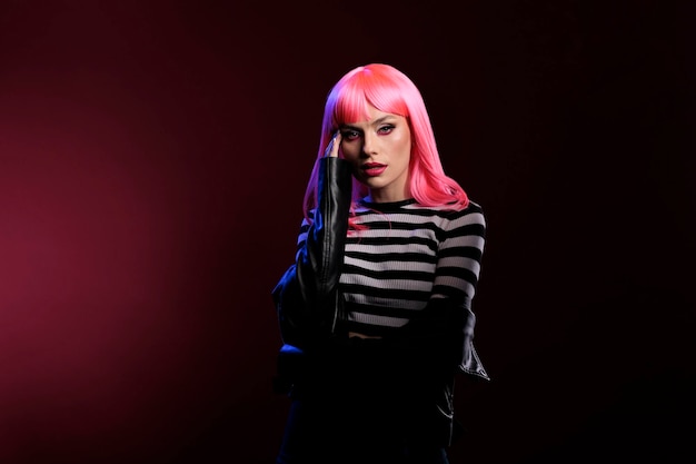 Jeune adulte élégant faisant des photos professionnelles en studio, portant une veste en cuir à la mode sur fond sombre. Posant dans des ombres noires, montrant la tendance de la mode punk cool devant la caméra.