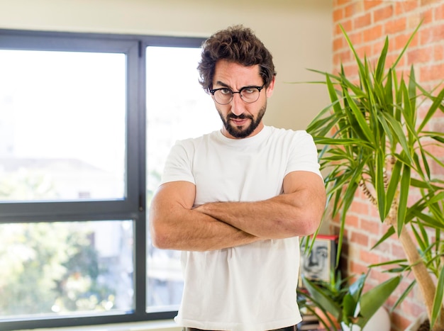 Jeune adulte fou avec pose expressive à l'intérieur d'une maison moderne