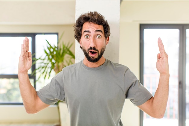 Jeune adulte fou avec pose expressive à l'intérieur d'une maison moderne