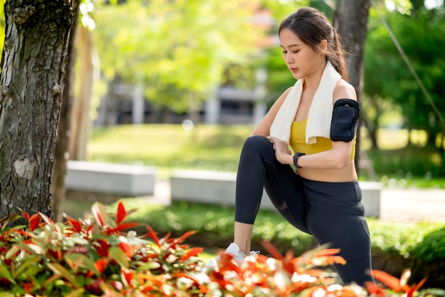 Jeune adulte gai asiatique Séduisant et fort matin qui s'étend avant de courir dans le parc Concept sportif Mode de vie sain Jeune femme fitness runner qui s'étend avant de courir sur le parc