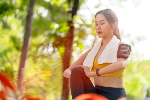 Jeune adulte gai asiatique Séduisant et fort matin qui s'étend avant de courir dans le parc Concept sportif Mode de vie sain Jeune femme fitness runner qui s'étend avant de courir sur le parc