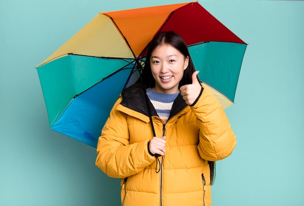 Jeune adulte jolie femme asiatique portant un anorak et un parapluie hiver et concept froid