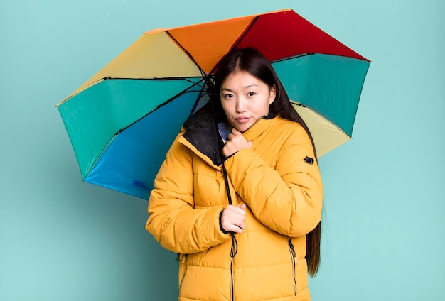 Jeune adulte jolie femme asiatique portant un anorak et un parapluie hiver et concept froid