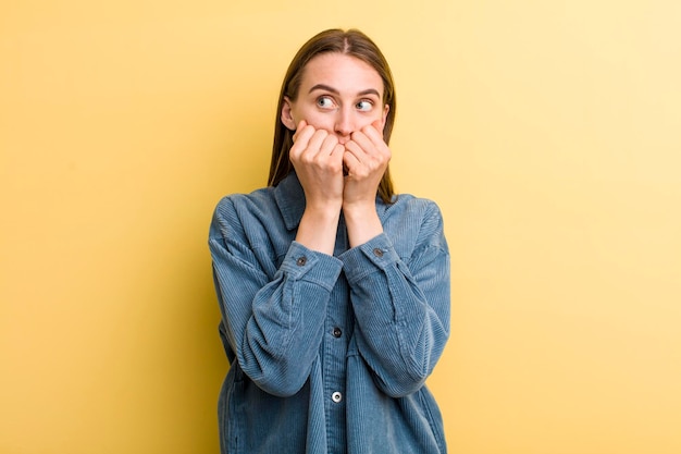 Jeune adulte jolie femme isolée contre le mur jaune