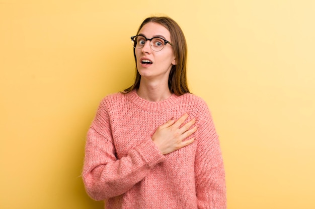 Jeune adulte jolie femme isolée contre le mur jaune