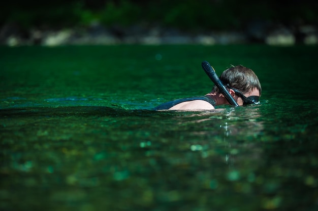 Jeune adulte plongée en apnée dans une rivière