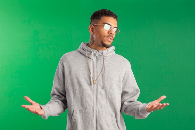 Jeune adulte de style hip hop en studio photo avec fond vert idéal pour le recadrage