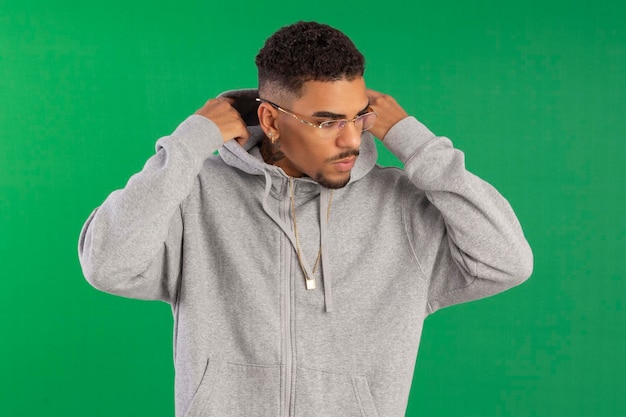 Jeune adulte de style hip hop en studio photo avec fond vert idéal pour le recadrage
