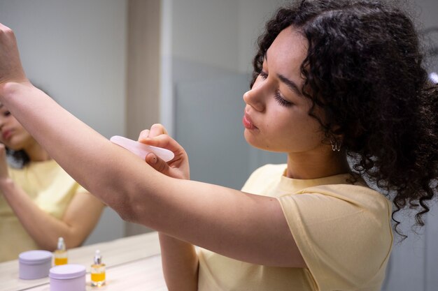 Photo jeune adulte utilisant un produit de soin du visage