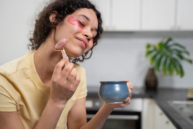 Photo jeune adulte utilisant un produit de soin du visage