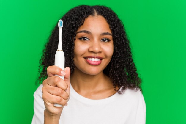 Jeune afro-américain à l'aide d'un brossage de dents isolé