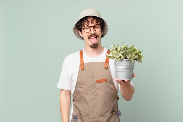 Jeune agriculteur avec une attitude joyeuse et rebelle, plaisantant et tirant la langue