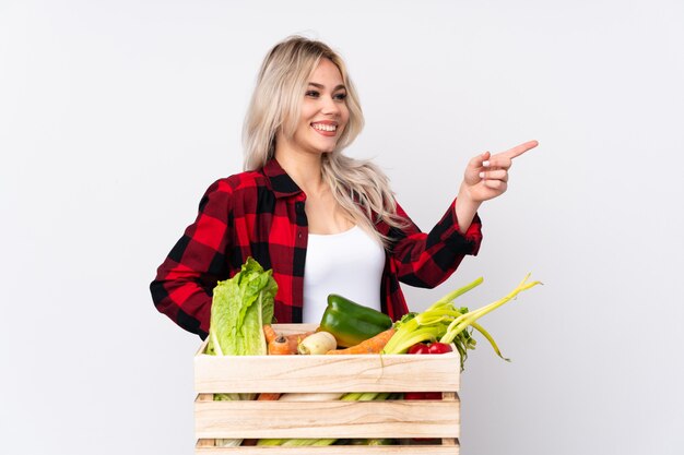 Jeune agriculteur caucasien femme sur mur blanc isolé