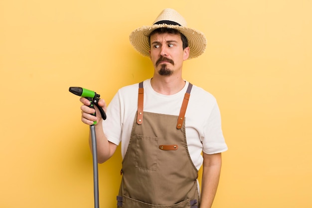 Jeune agriculteur avec un concept de jardinage de tuyau