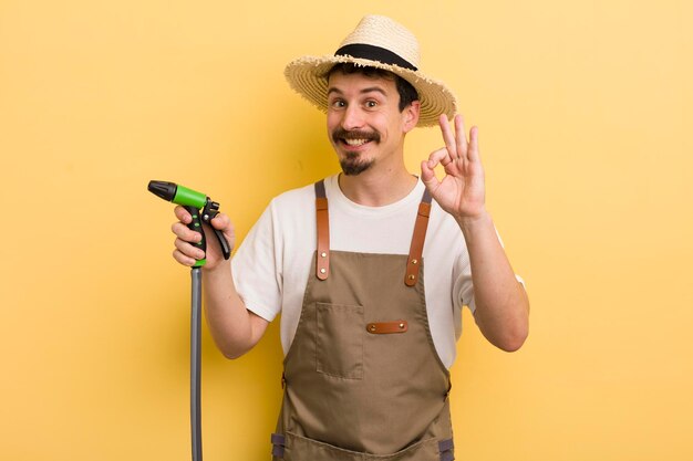 Jeune agriculteur avec un concept de jardinage de tuyau