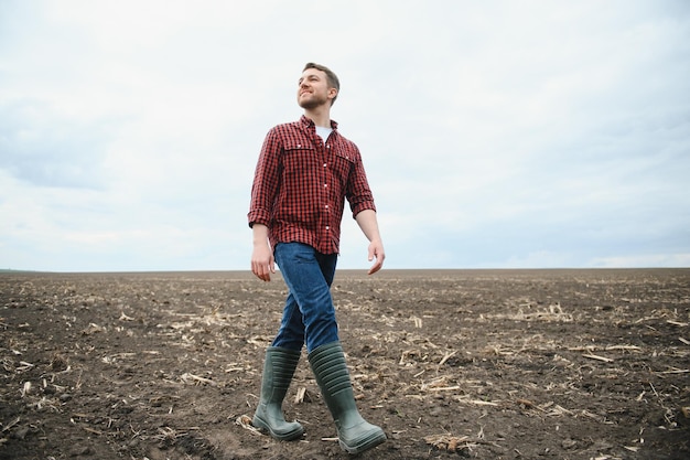 Jeune agriculteur dans un champ de semis de maïs contrôlé