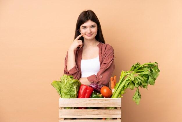 Jeune agriculteur fille avec des légumes fraîchement cueillis dans une boîte