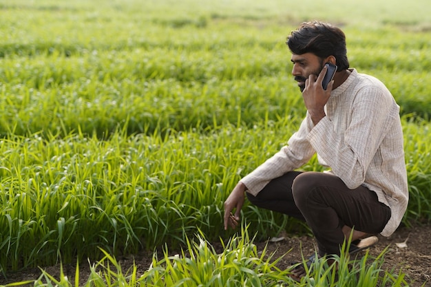 Jeune agriculteur indien à l'aide d'un téléphone intelligent