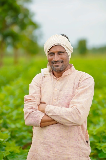 Jeune agriculteur indien debout dans le domaine de l'agriculture du coton.