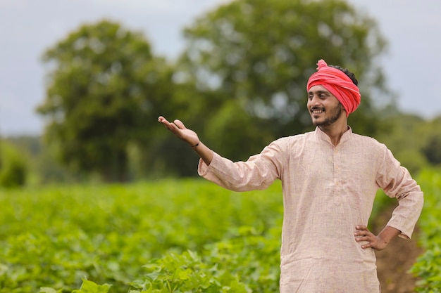 Jeune agriculteur indien debout sur le terrain agricole.