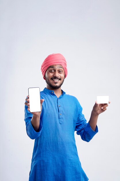 Jeune agriculteur indien montrant la carte et le smartphone sur fond blanc.