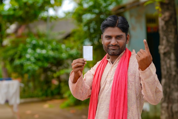 Jeune agriculteur indien montrant le doigt après avoir voté. signe de vote en inde