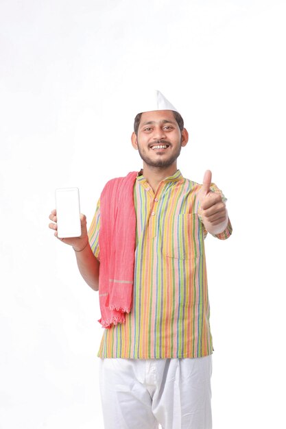 Jeune agriculteur indien montrant un smartphone sur fond blanc.