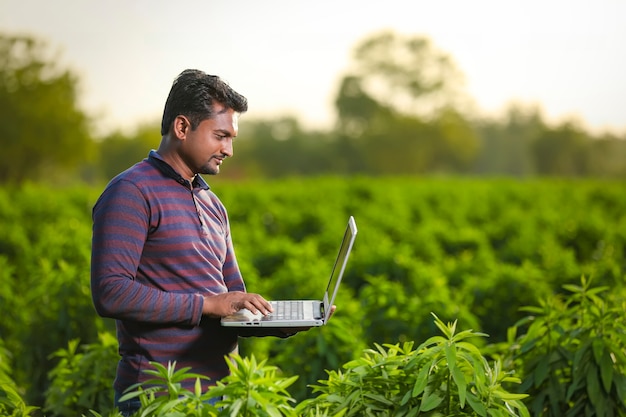 Jeune agriculteur indien avec ordinateur portable