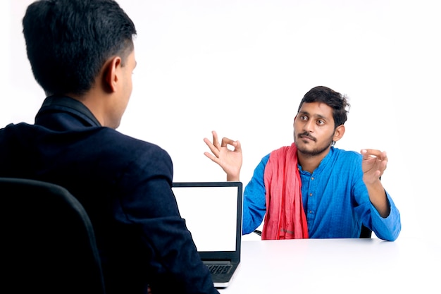 Jeune agriculteur indien parlant à un banquier ou à un officier au bureau.