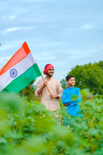 Photo jeune agriculteur indien et son enfant avec drapeau indien