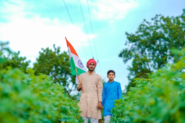 Jeune agriculteur indien et son enfant avec drapeau indien