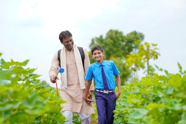 Jeune agriculteur indien avec son fils sur le terrain de l'agriculture verte.