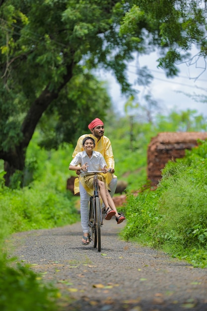 Jeune agriculteur indien avec son fils à vélo