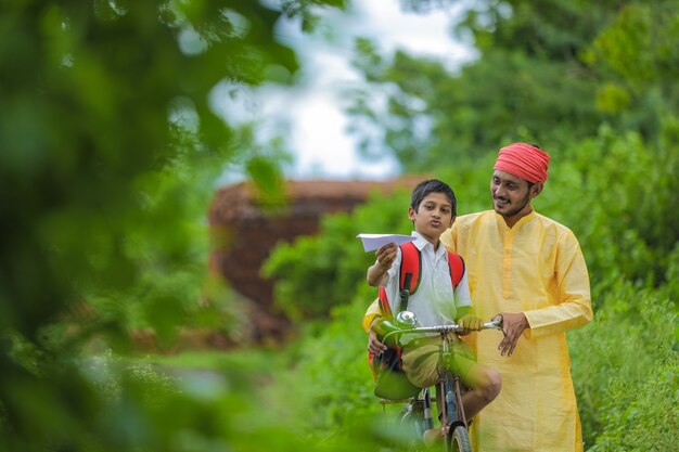 Jeune agriculteur indien et son fils vont à l'école