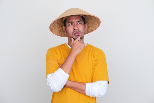 Jeune agriculteur indonésien pensant à quelque chose avec une expression sérieuse