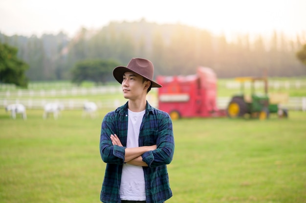 Jeune agriculteur travaillant sur un beau paysage de champ de pays à l'aube