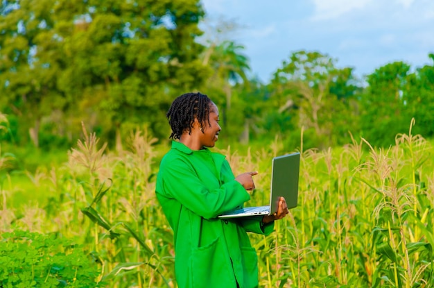 Jeune agricultrice se sentant excitée alors qu'elle utilise son système dans une ferme de maïs tout en pointant