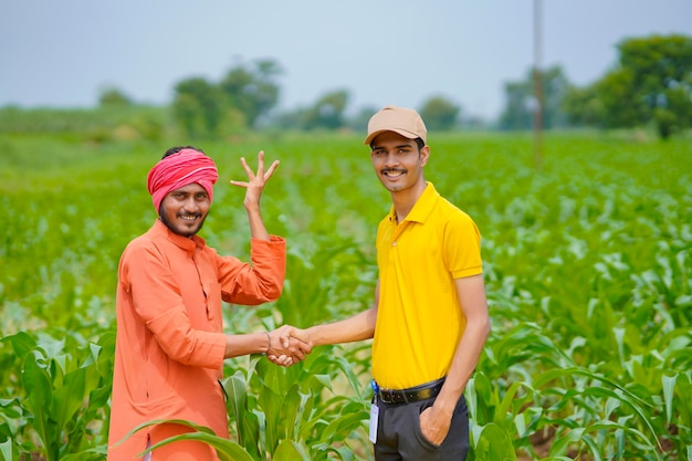 Un jeune agronome ou banquier indien serre la main d'un agriculteur dans un domaine agricole.