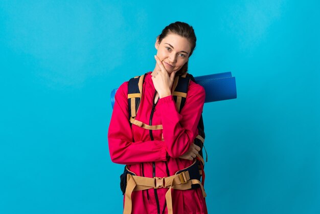 Jeune alpiniste femme sur fond bleu isolé heureux et souriant