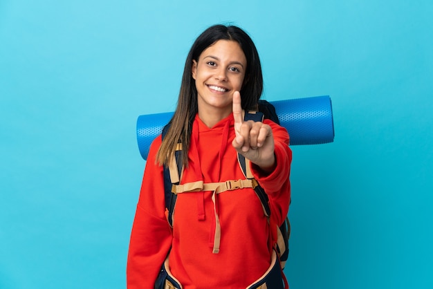 Jeune alpiniste femme avec sac à dos montrant et soulevant un doigt