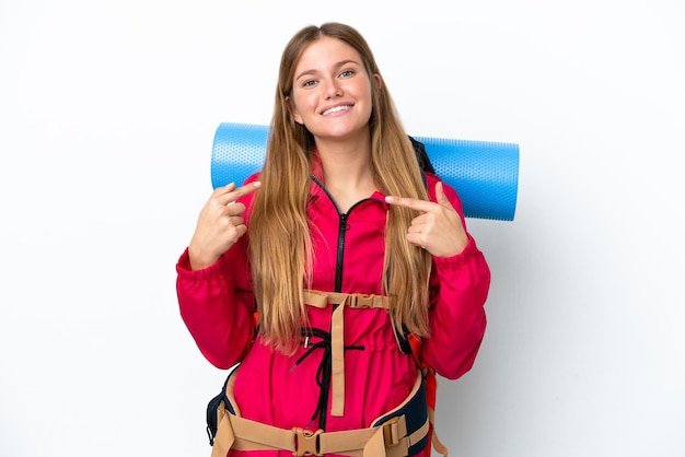 Jeune alpiniste avec un gros sac à dos sur fond blanc isolé avec une expression faciale surprise